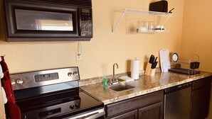 Una cucina attrezzata con forno a microonde, fornello, lavello e scolapiatti.