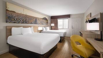 Een hotelkamer met twee bedden, een bureau, een stoel, een groot schilderij en een raam.