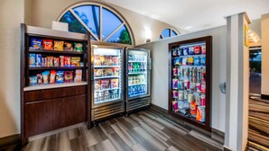 Een automatenzone met snacks en drankjes, waaronder chips, frisdranken en flessenwater.