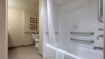 A bathroom with a bathtub, a toilet, and a shower curtain.