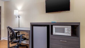A compact room with a desk, a chair, a flat-screen TV mounted on the wall, and a microwave built into a cabinet. - Econo Lodge Chattanooga Northeast - Ooltewah (Chattanooga)