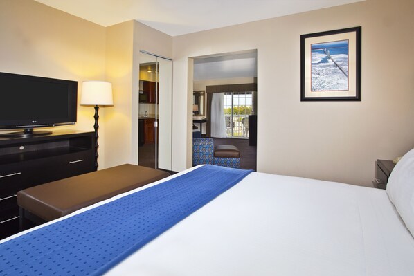 A hotel room with a bed, a TV, a desk, and a bathroom visible through an open door. - Holiday Inn Express Mackinaw City by IHG (Mackinaw City)
