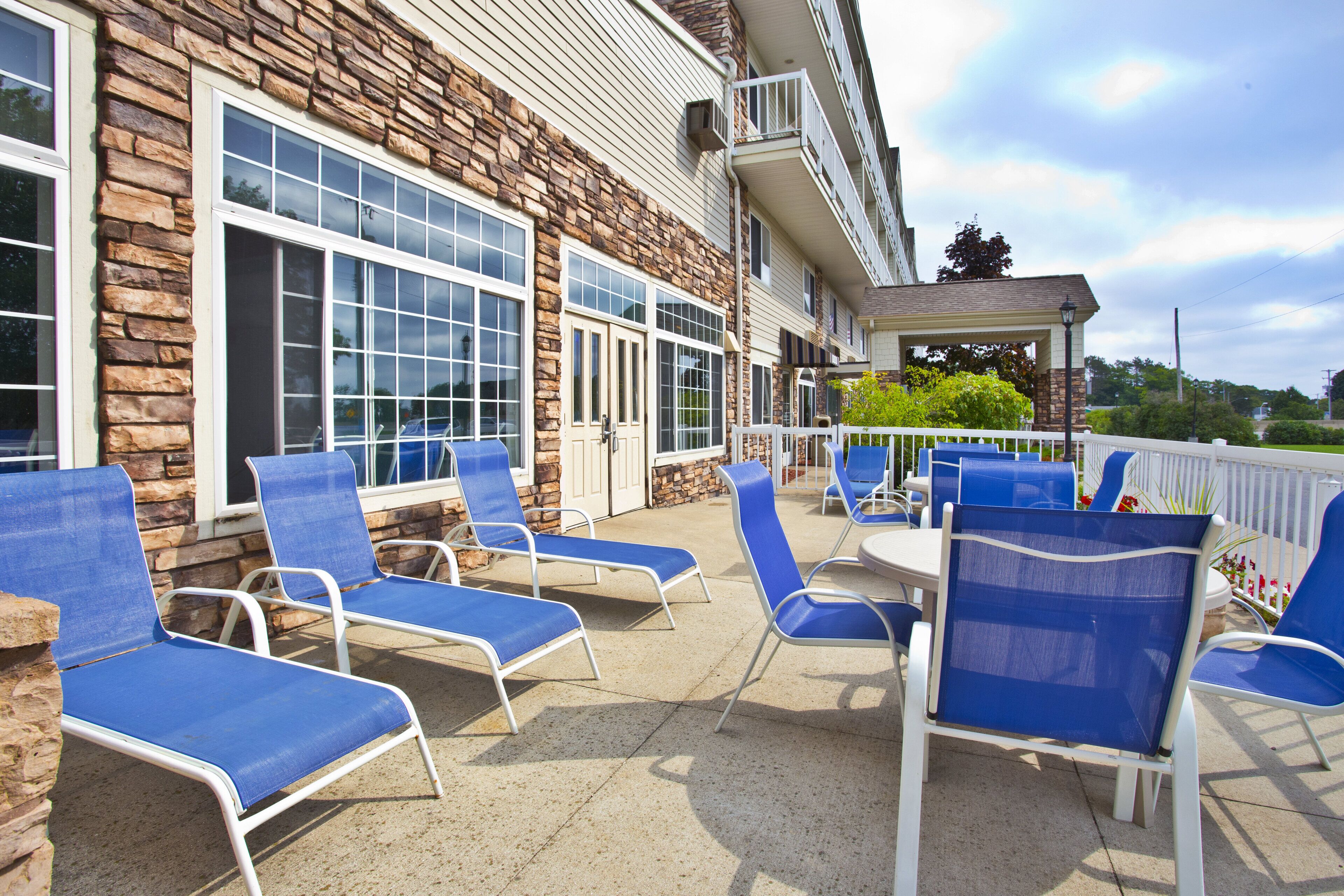 A patio area with outdoor seating and a stone building facade.