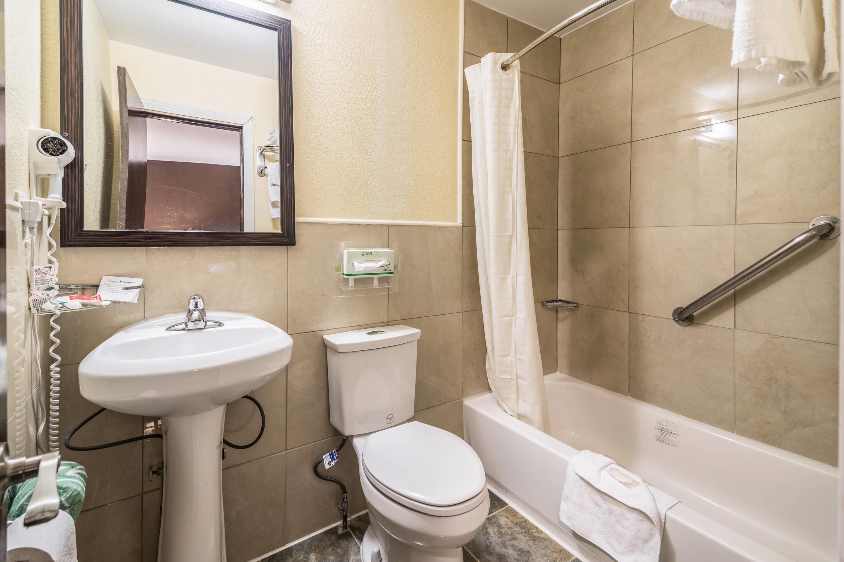 Un baño con lavamanos, inodoro y bañera.