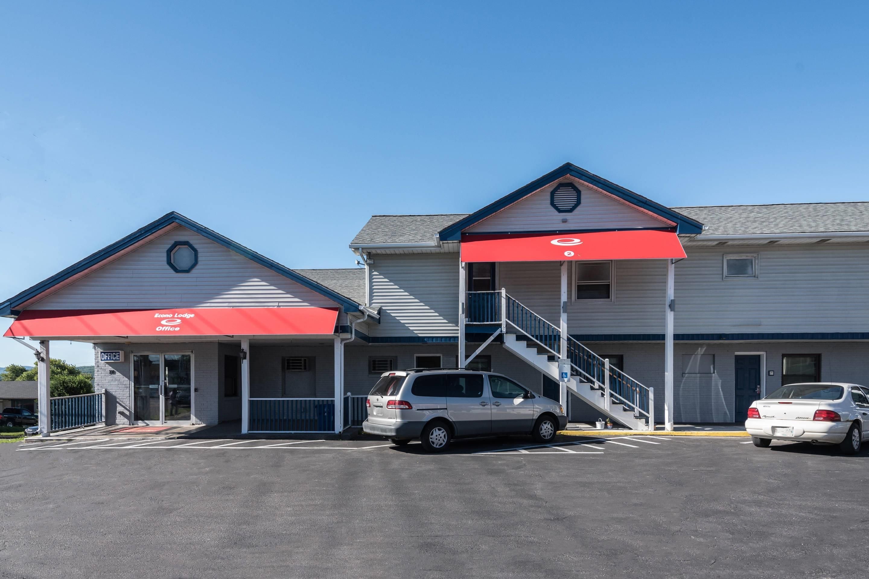 A two-story building with a red awning and a staircase leading to the upper level.