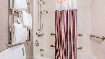 Une salle de bain équipée d’une douche, d’une baignoire et d’un porte-serviettes avec plusieurs serviettes.