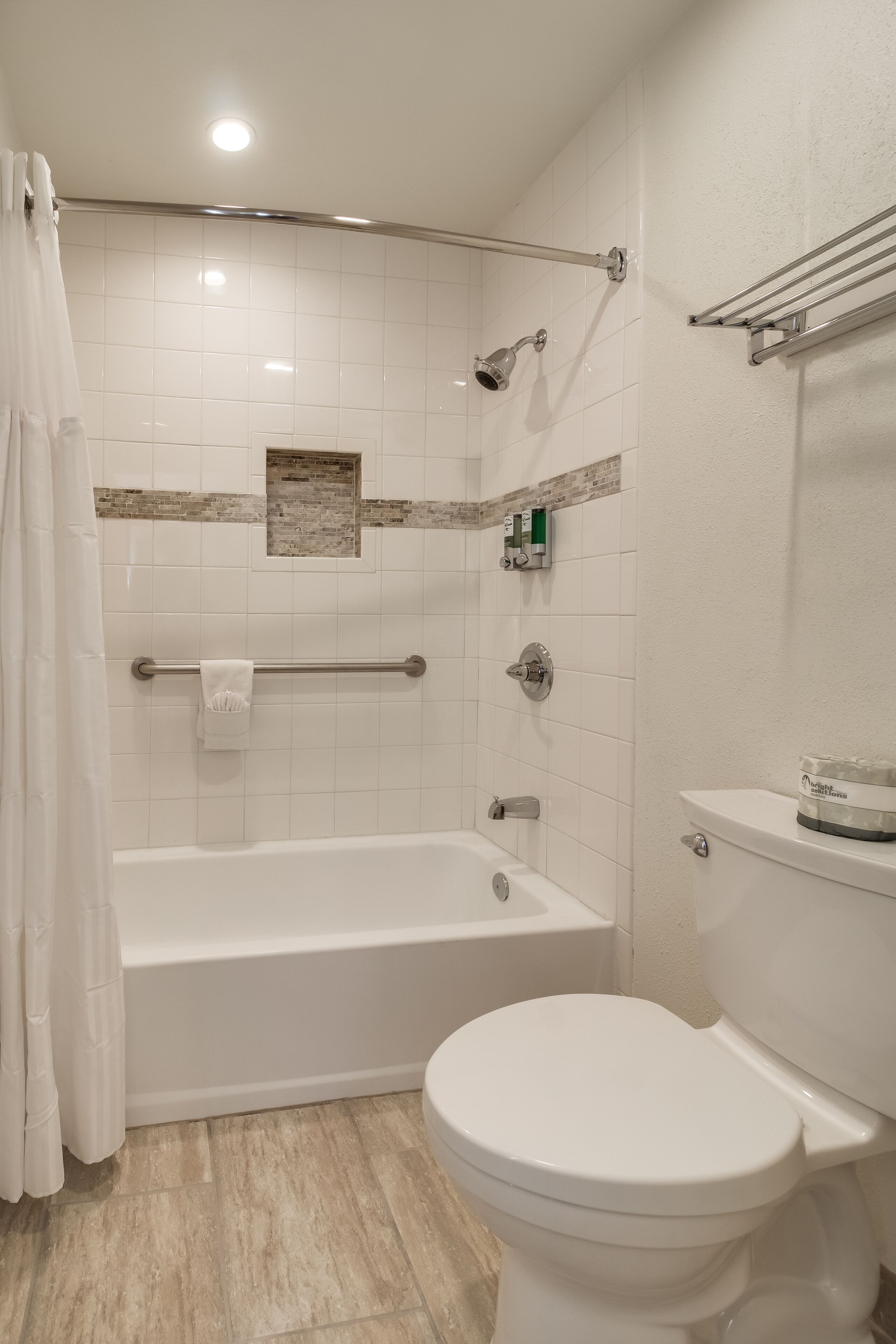 A modern bathroom with a bathtub, toilet, and shower area.