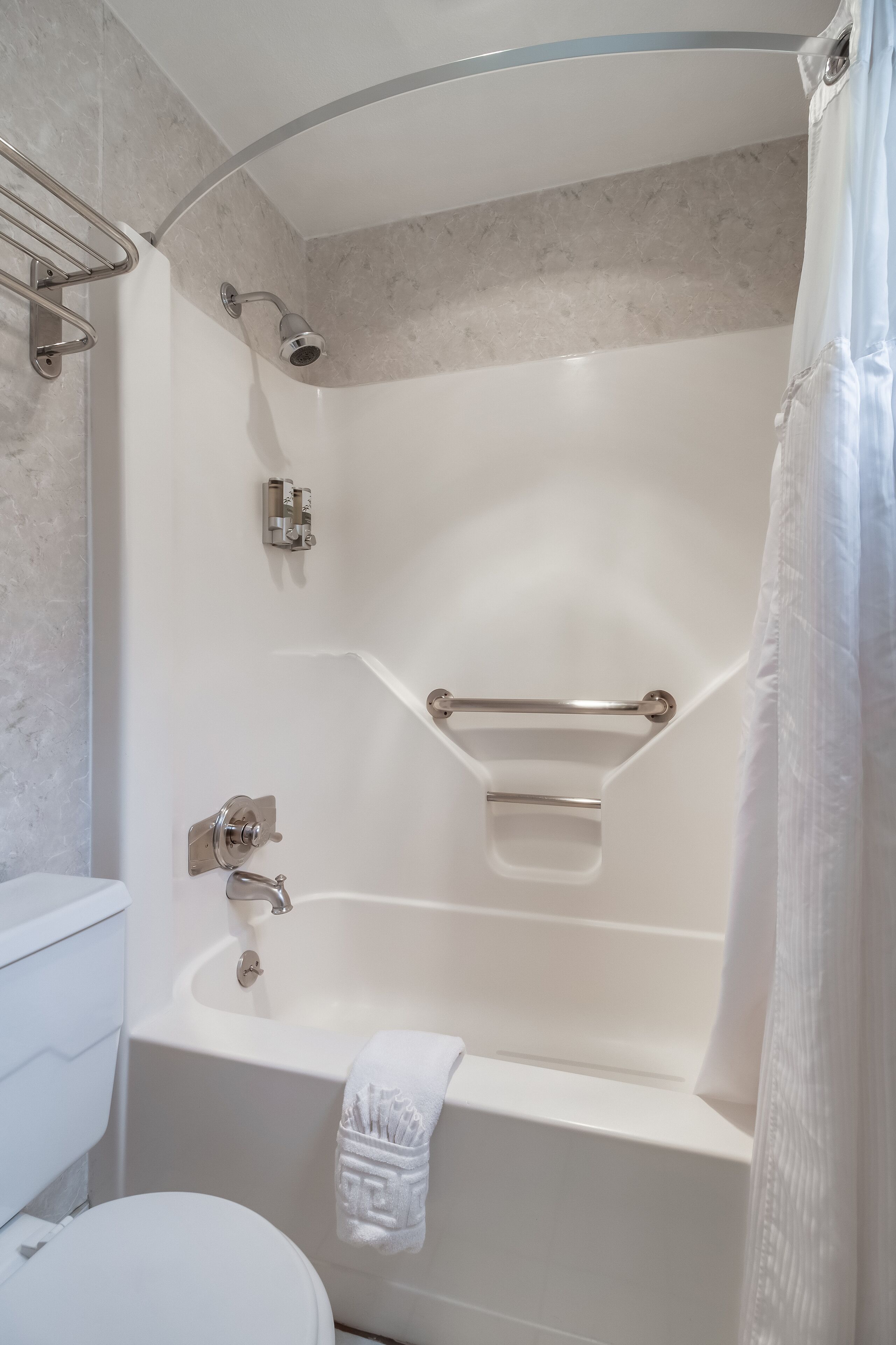 Un baño moderno con bañera, inodoro y zona de ducha.