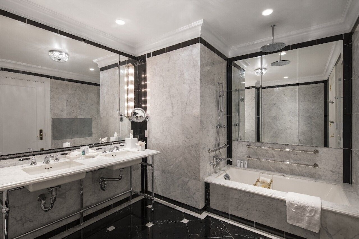 A modern bathroom with a large vanity, a bathtub, and a separate shower area.
