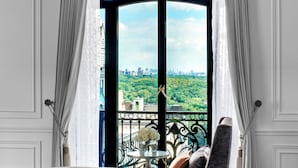 A modern room with a large window, a grey sofa, and a decorative ball. - The St. Regis New York (New York)