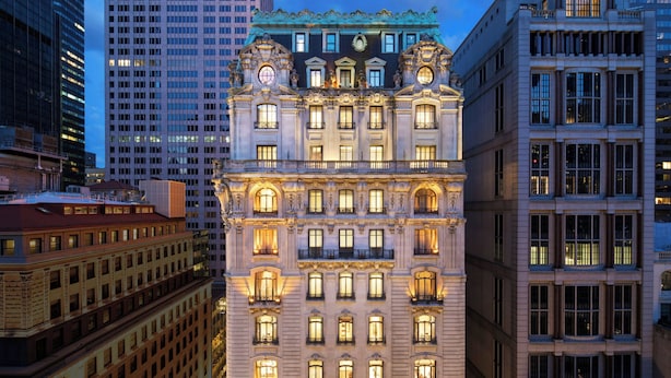 A historic building with ornate architectural details, multiple floors, and illuminated windows. - The St. Regis New York (New York)