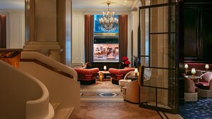 A luxurious lobby with a grand chandelier, plush seating, and a view into a high-end restaurant. - The St. Regis New York (New York)