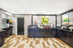 Een moderne keuken met een centraal aanrecht, koffieapparaten en een koelkast.