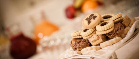 A dessert display with various cookies and pastries on a stand.