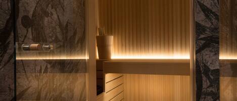 A sauna with wooden benches and a wall with a floral pattern.