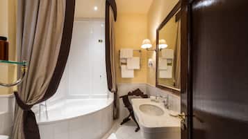 Un bagno con una vasca, un lavandino, uno specchio e una tenda per la doccia.