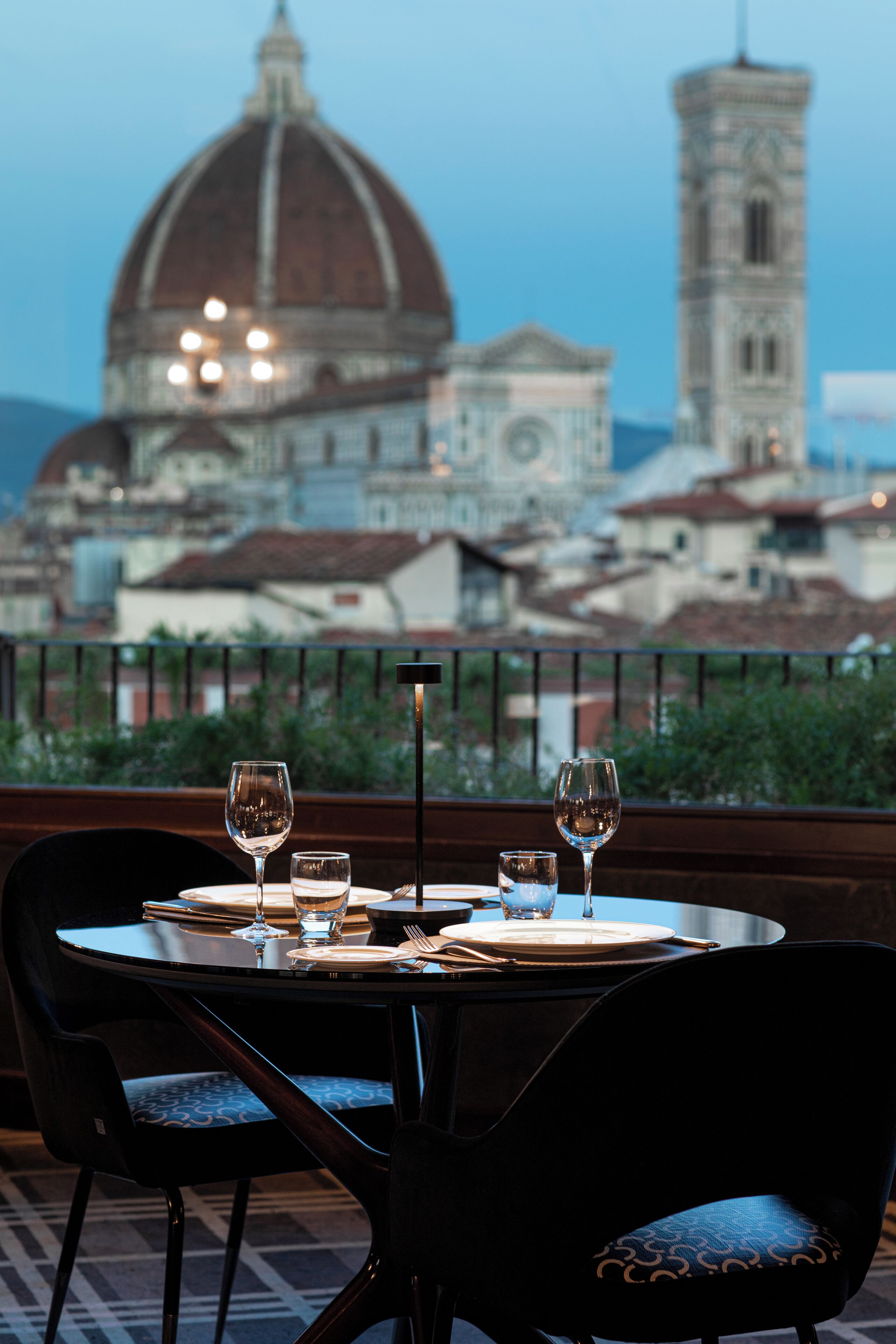 A dining table with chairs, a view of a dome and tower in the background.