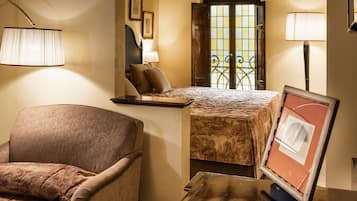 Una habitación compacta con cama, una silla, escritorio y ventana con vistas.