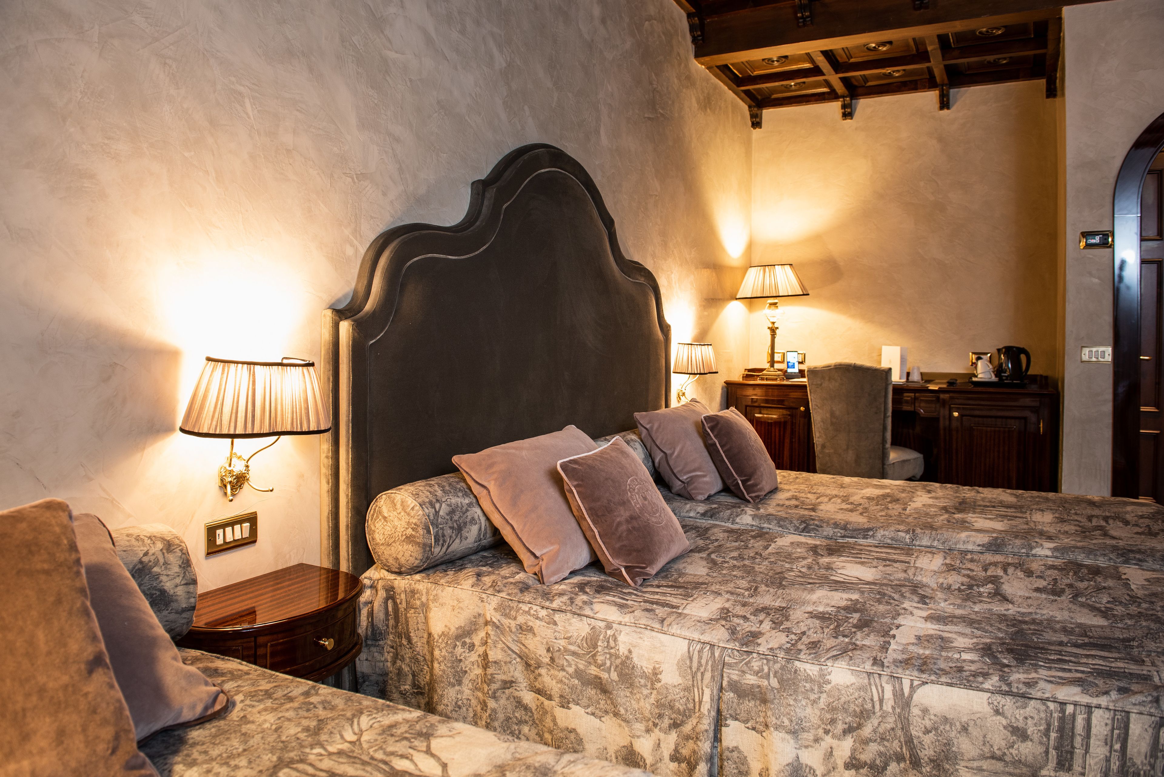 Ein Schlafzimmer mit einem großen Bett, zwei Nachttischen und einem Beistelltisch.