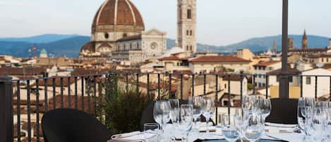 Mesa lista para comer con vista a un edificio histórico y una torre al fondo.