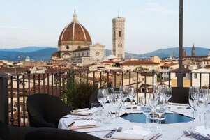 A table set for dining with a view of a historic building and a tower in the background.