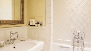 A bathroom with a white sink, a mirror, and a bathtub.