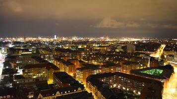 Paisagem urbana noturna com edifícios urbanos densos e ruas iluminadas.