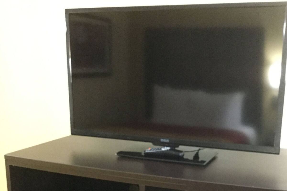 A flat-screen TV on a wooden stand.
