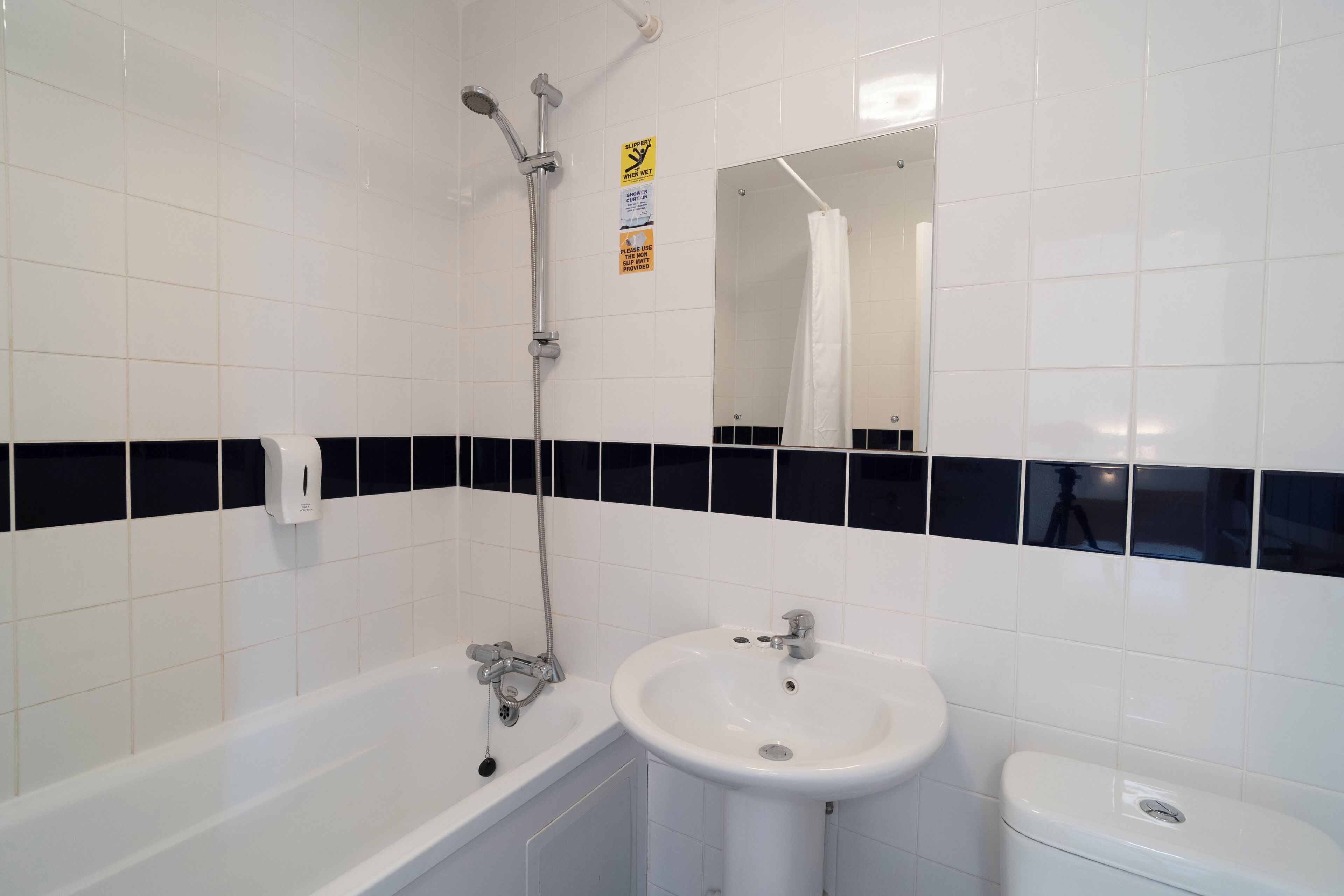 A bathroom with a bathtub, a sink, and a toilet.