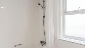Un baño con ducha, bañera y ventana.