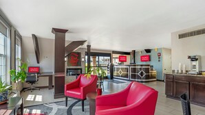 A hotel lobby with red chairs, a reception desk, and a kitchen area. - Red Roof Inn Gastonia (Gastonia)