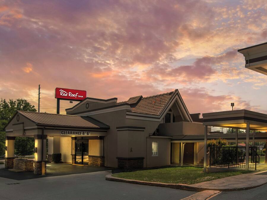 A Red Roof Inn with a covered parking area, a clear sign, and a well-lit entrance.