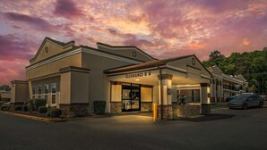 A hotel with a covered entrance, a sign reading 'Clearance B&B,' and a parking lot with a car. - Red Roof Inn Gastonia (Gastonia)