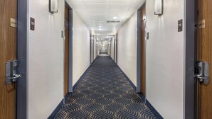 A hotel hallway with a patterned carpet, doors numbered 109 and 110, and a 'Welcome' sign on each door. - Red Roof Inn Gastonia (Gastonia)