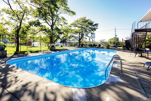 Piscine extérieure en saison, chaises longues