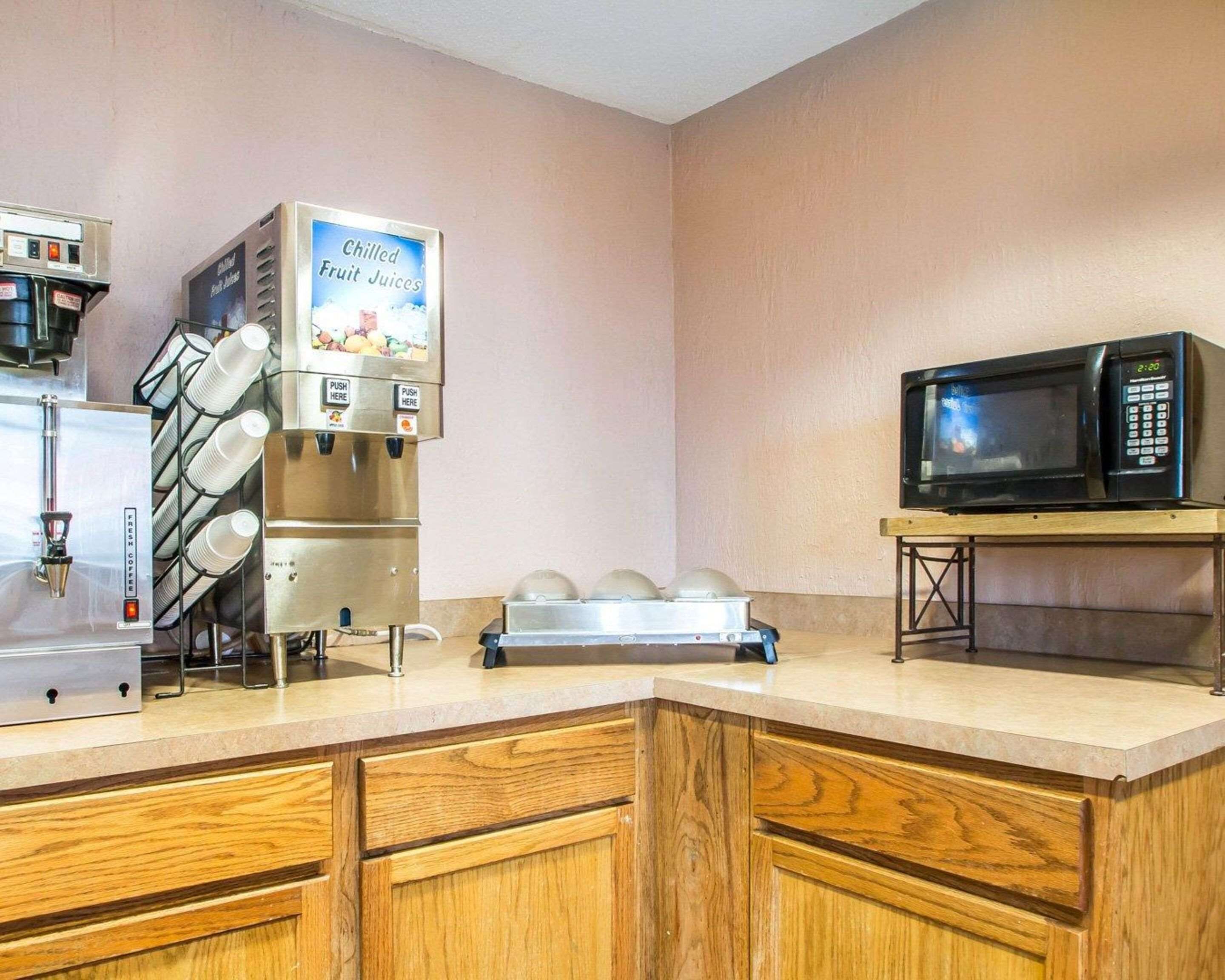 Una kitchenette equipada con cafetera, microondas y dispensador de zumo de frutas.