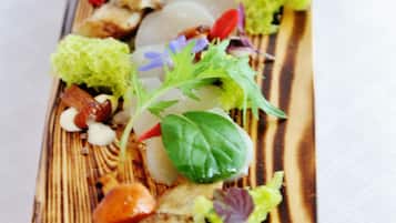 Una tabla de madera con una variedad de alimentos, incluyendo verduras, carne y adornos.