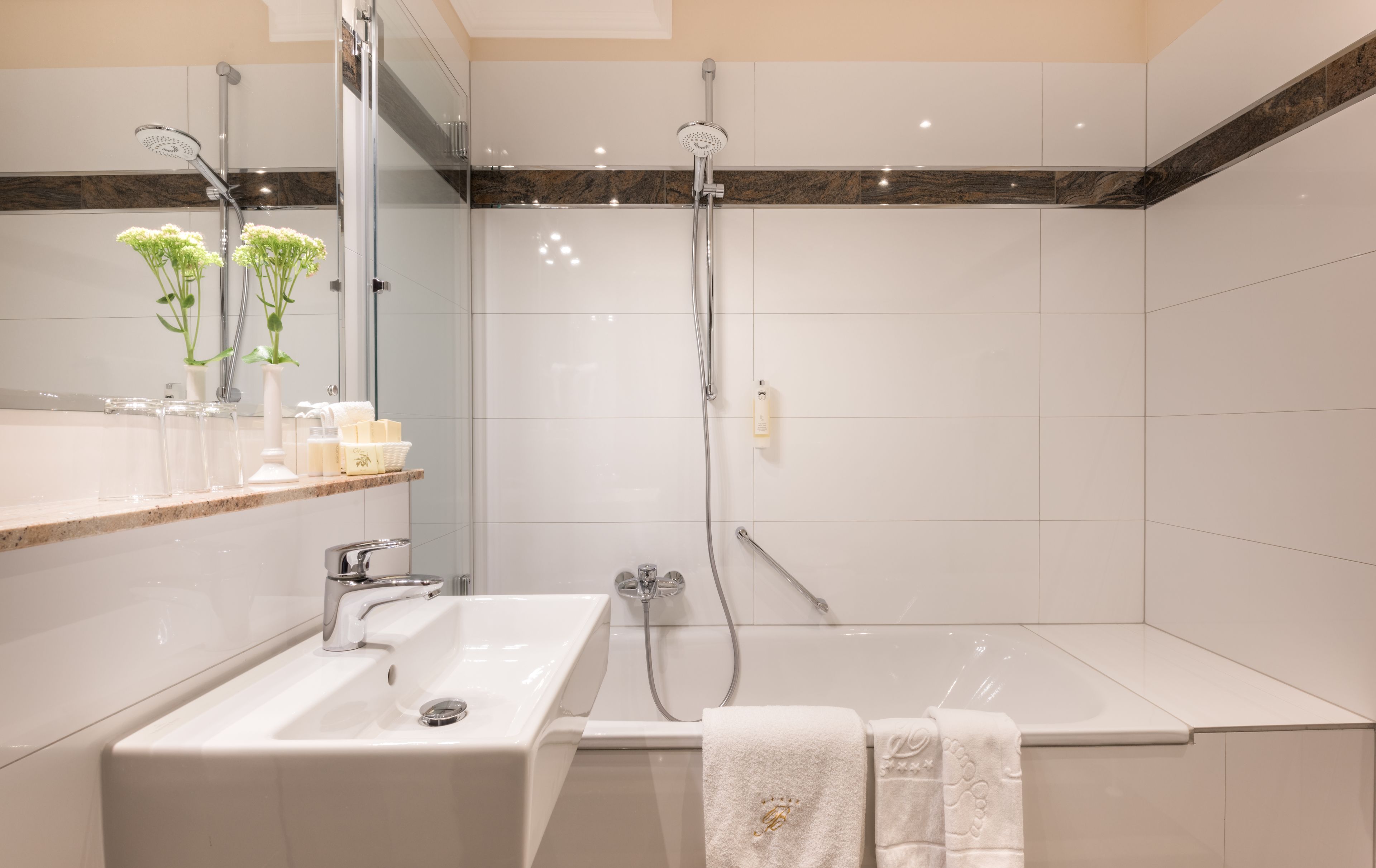 A modern bathroom with a sink, mirror, and shower.
