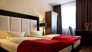 Una habitación de hotel con una cama grande, un escritorio y un armario.