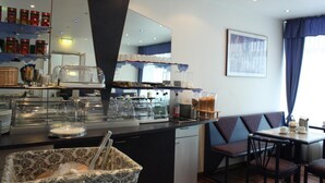 Un comedor para el desayuno con una barra de buffet, asientos y un espejo grande.