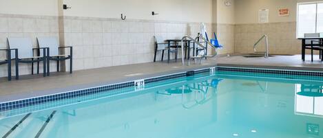 A swimming pool with clear lanes, a changing room with chairs, and a no diving allowed sign.