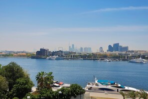 A waterfront cityscape with a marina, boats, and a skyline of buildings. - Sheraton Dubai Creek Hotel & Towers (Dubai)