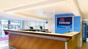 Ein Travelodge-Rezeptionstresen mit einem Schild, das die Adresse London Kings Cross Royal Scot angibt.