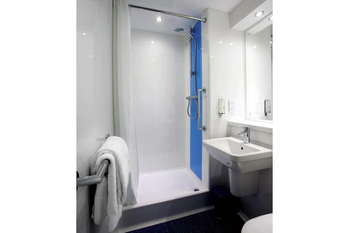 Une salle de bain moderne équipée d’une douche, d’un lavabo et de toilettes.