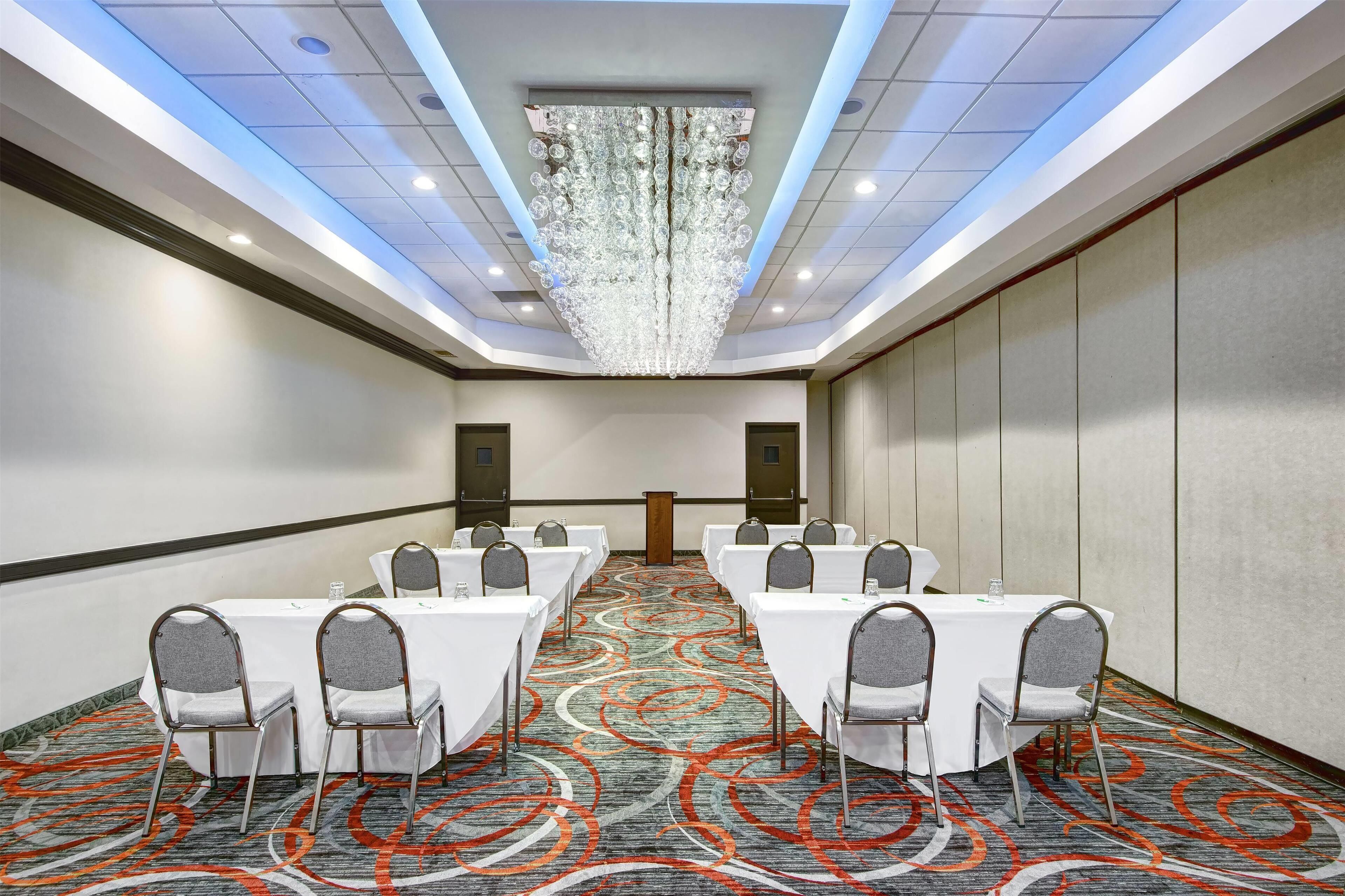 A conference room with a long table, chairs, and a chandelier.