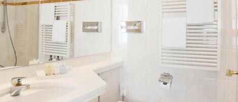 A bathroom with a sink, toilet, and shower.