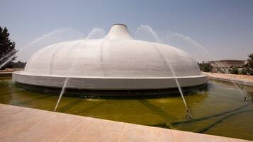A large, white, dome-shaped water fountain with multiple jets spraying water into the air.