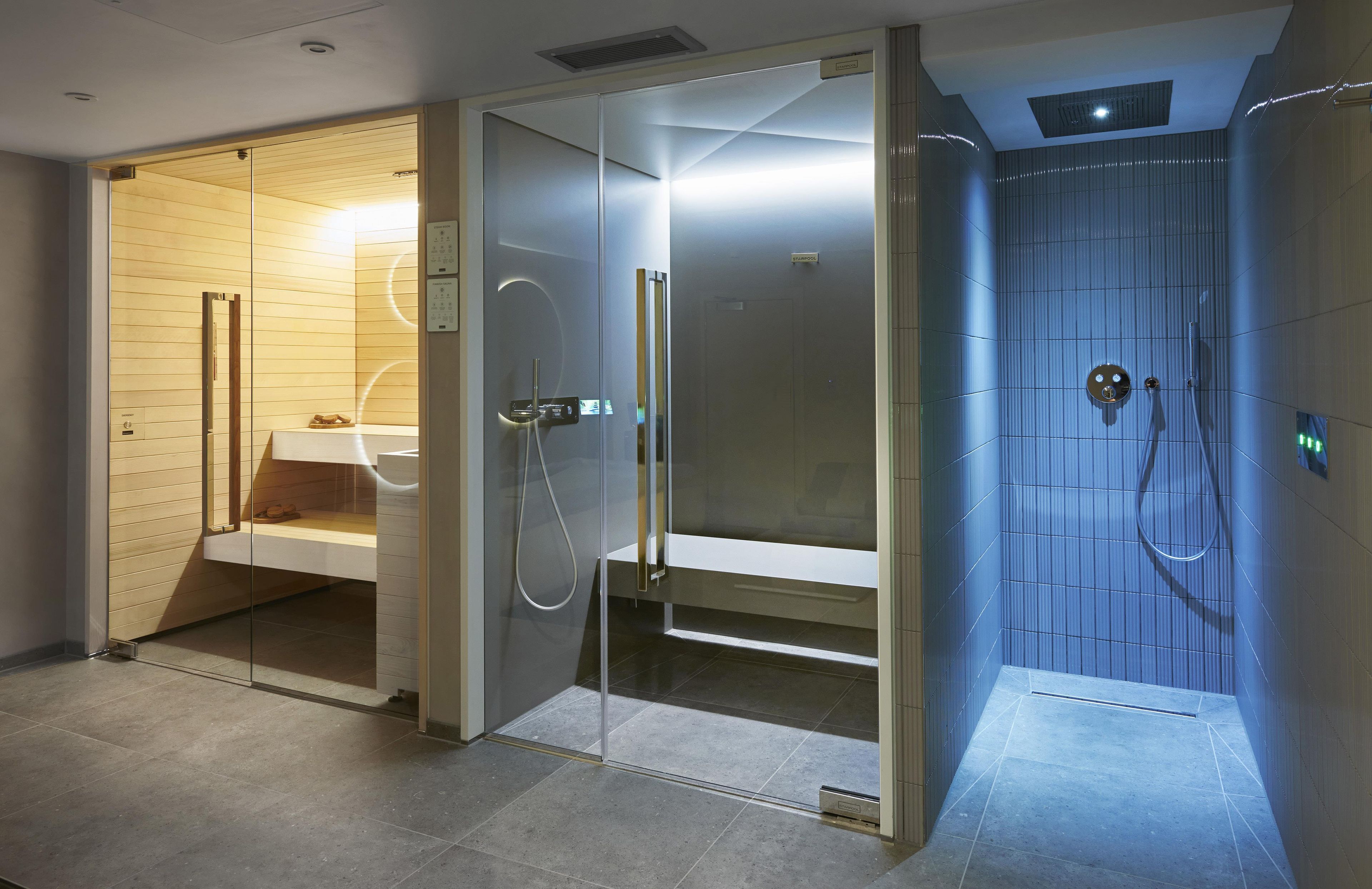 Une salle de bain moderne avec une douche à parois de verre, des toilettes apparentes et un espace lavabo.