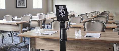 A conference room with rows of tables, chairs, and a Starpool wellness concept kiosk.