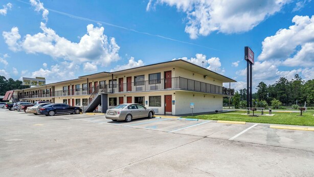 A two-story motel with a parking lot. - Red Roof Inn MacClenny (MacClenny)